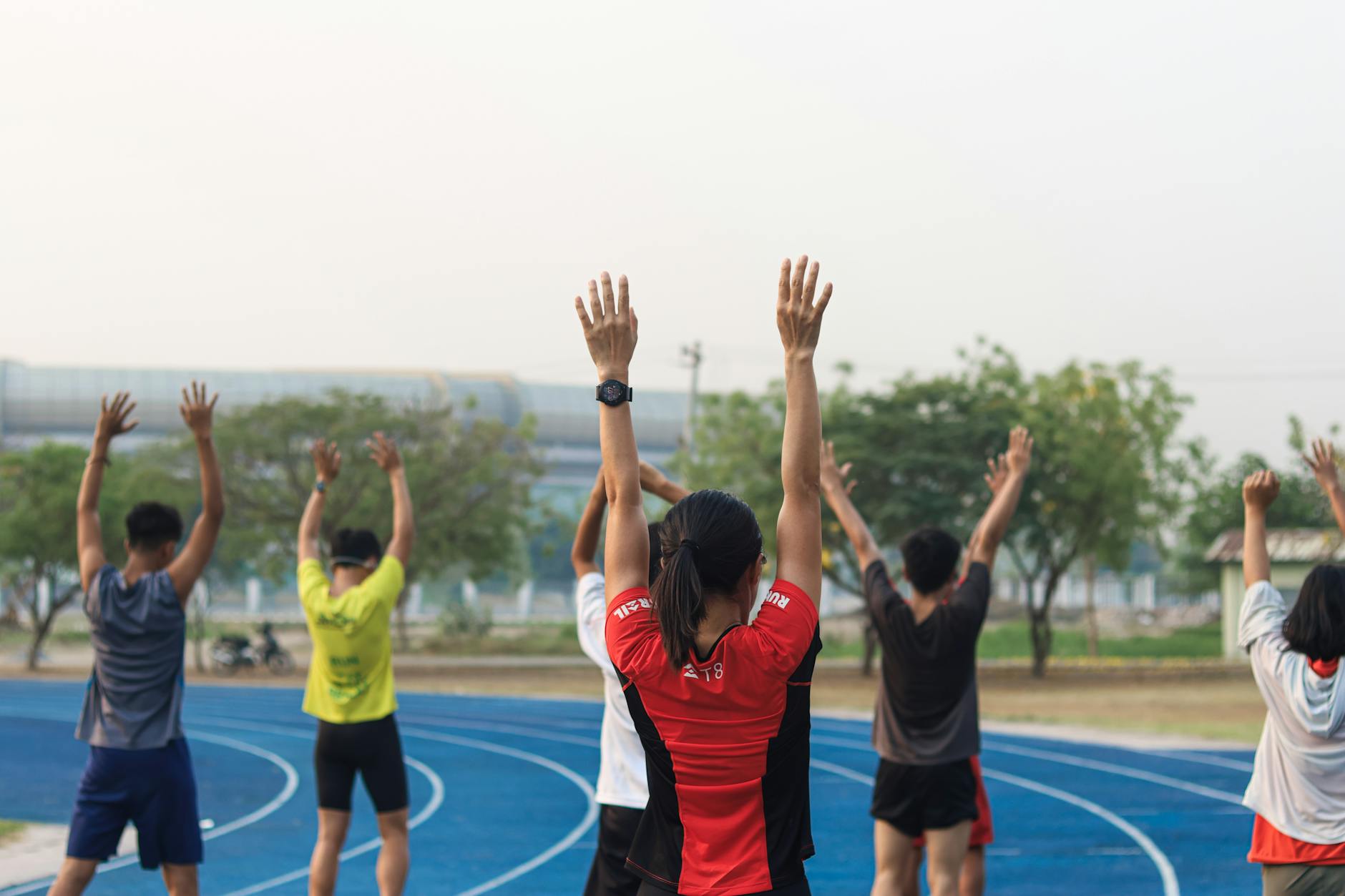 A group of adults exercising on a blue running track in Mandalay, Myanmar. (Photo by Nay Nyo on Pexels)