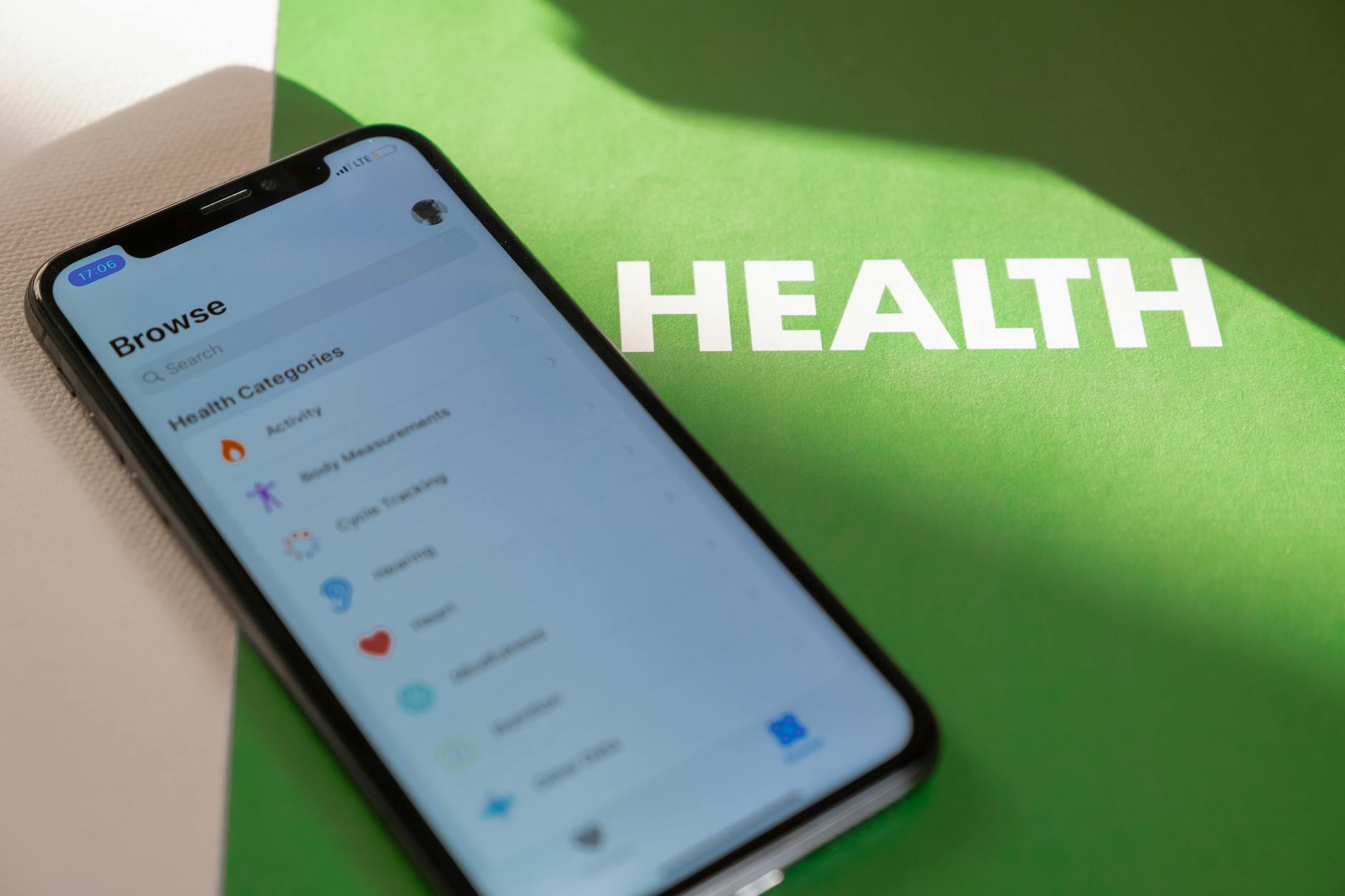Close-up of a smartphone displaying a health app on a green surface with 'HEALTH' text. (Photo by Polina Zimmerman on Pexels)