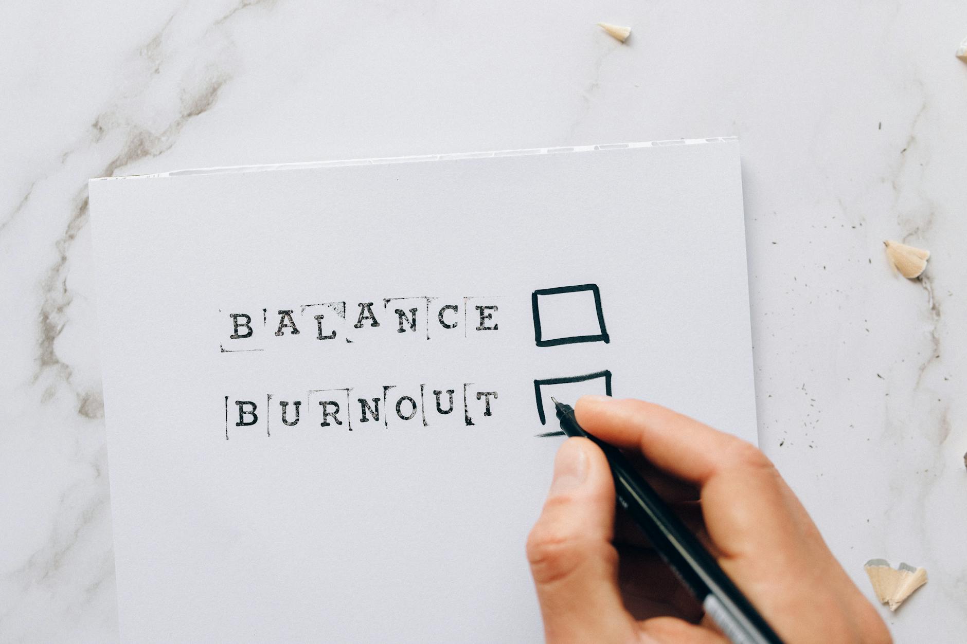 Close-up of a hand hovering over a checklist with options for balance or burnout, symbolizing str... (Photo by Nataliya Vaitkevich on Pexels)