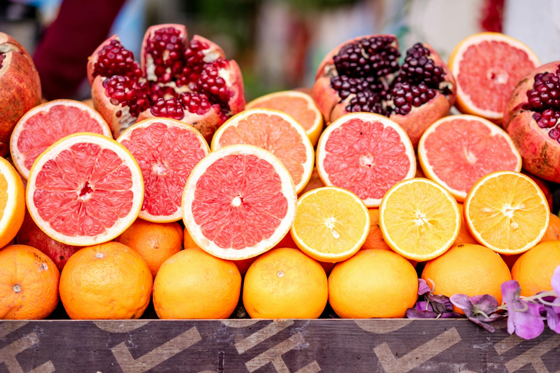 Vibrant display of sliced grapefruits, oranges, and pomegranates showcasing fresh and healthy tro... (Photo by Atlantic Ambience on Pexels)